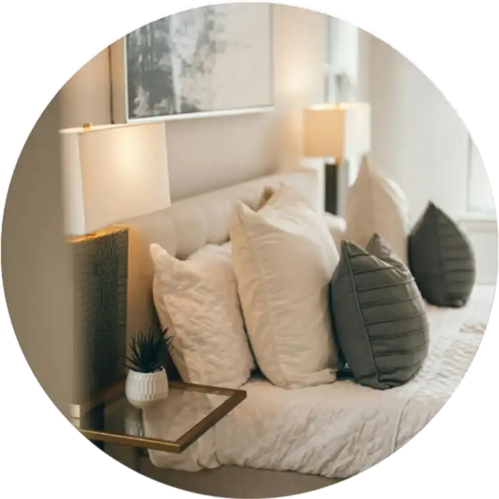 Image d'un lit blanc avec des coussins verts dans un chambre de coucher blanc et zen pour montrer l'efficacité du Staging express